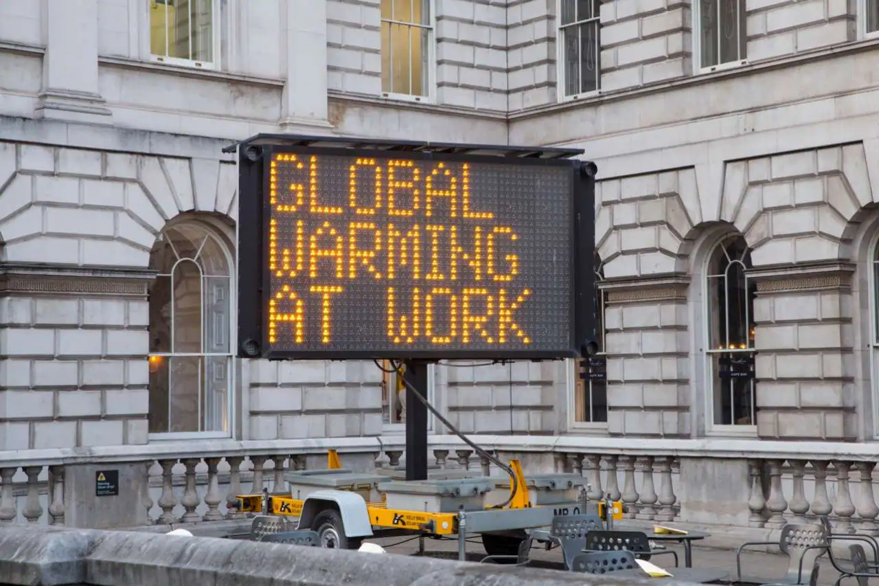 A digital signage that says "Global Warming at Work"